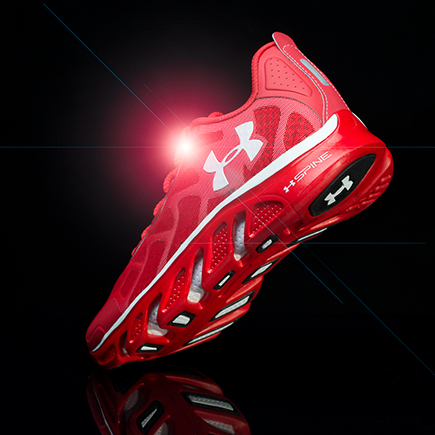 Under Armour athletic shoe photographed with dynamic studio lighting and floating composition for high-end commercial sports photography.
